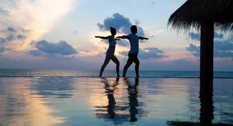 mnld_couple_yoga_on_ocean_pool_view_2_1920x1037